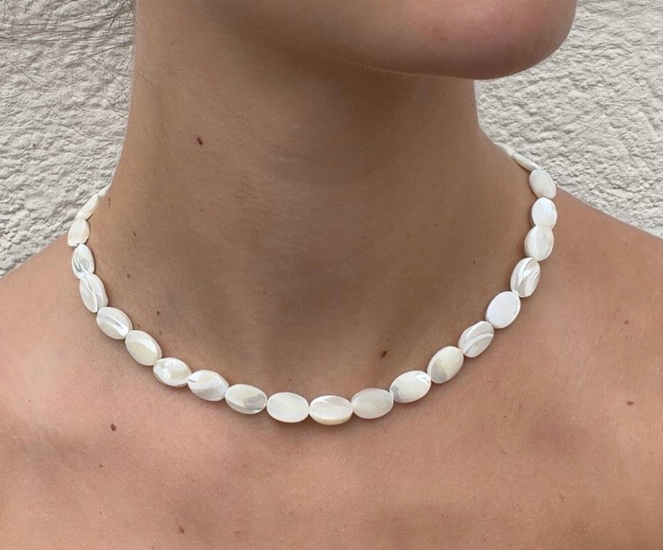 Collar Nácar de cuentas ovaladas de nácar natural, mostrado sobre el cuello de una modelo.