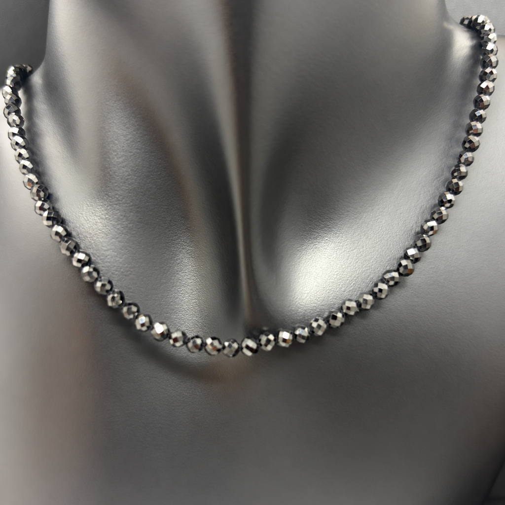 Fotografía del Collar La Fosca sobre busto negro, con pequeñas cuentas de ónix negro facetado y sus reflejos naturales.