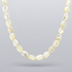 Collar Nácar de cuentas ovaladas de nácar natural, suspendido sobre fondo gris claro en degradado con una sombra suave.