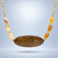 Collar Ocre de broncita ovalada, seis cuentas de cuarzo rutilado y citrino, suspendido sobre fondo gris claro.