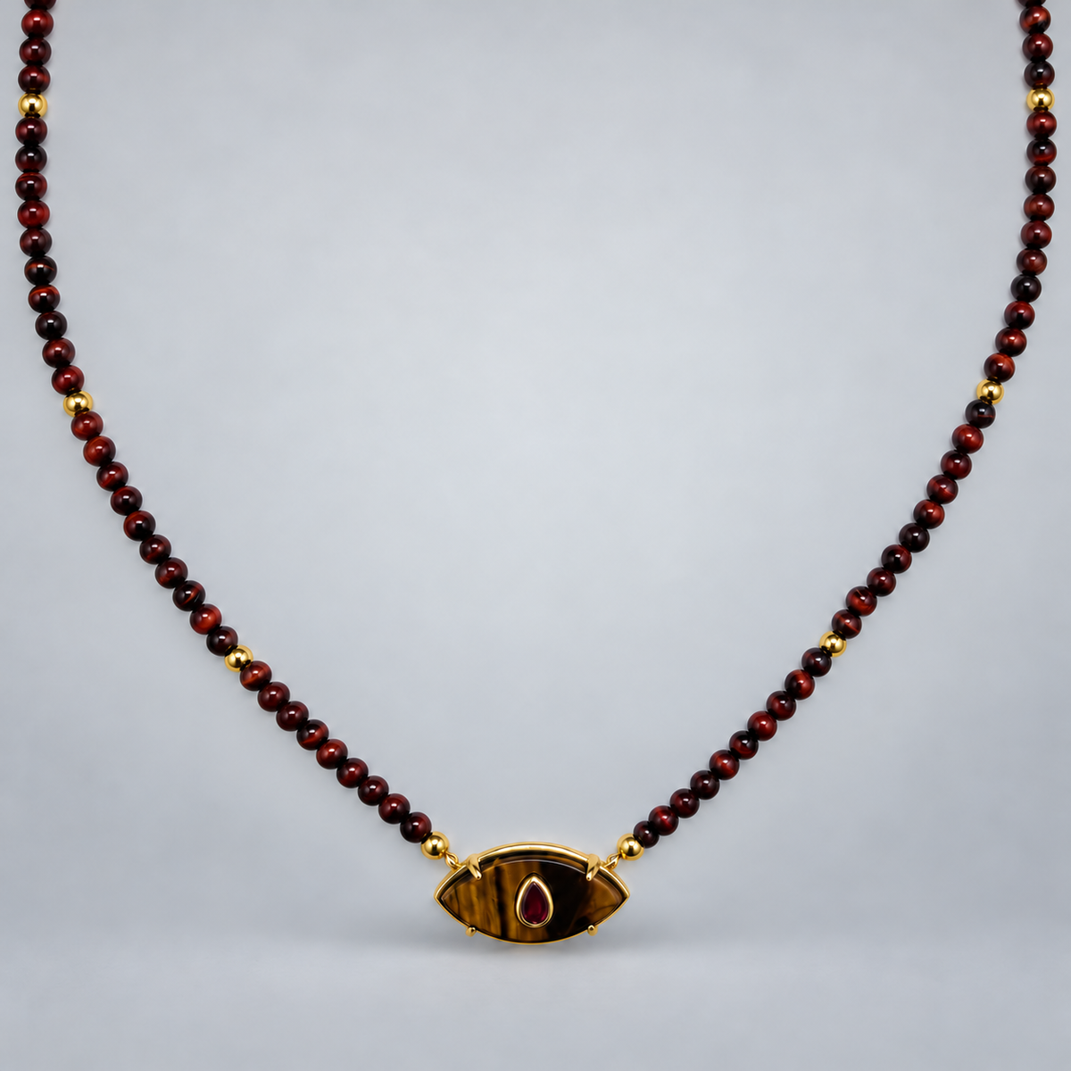 Collar de ojo de tigre y rubí reconstituido, suspendido sobre fondo gris claro.