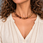 Collar Empordà de ágatas marrones, de 36 cm, sobre una modelo de pelo rizado con blusa beige y detalles de encaje.
